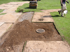 Catch basin excavation backfilled with soil and sand.