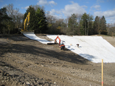 TDS crews unroll and fit Bentonite liner panels to irrigation pond walls.