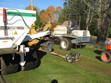 A compactor being pulled behind the trencher.
